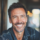 Homme souriant avec veste en jean, intérieur flou